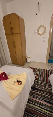 a bedroom with a bed and a wooden cabinet at MaMa Africa Nubian Guest House in Aswan