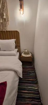 a bedroom with a bed with a night stand next to it at MaMa Africa Nubian Guest House in Aswan