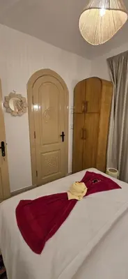 a bedroom with a bed with a red robe on it at MaMa Africa Nubian Guest House in Aswan