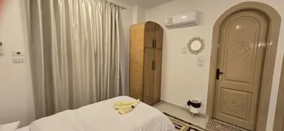 a bedroom with a bed with a yellow towel on it at MaMa Africa Nubian Guest House in Aswan