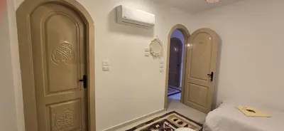 two doors in a room with a bed and a hallway at MaMa Africa Nubian Guest House in Aswan
