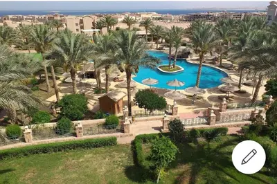 an aerial view of a resort with a pool and palm trees at Apartment with garden in sahl hasheesh in Hurghada