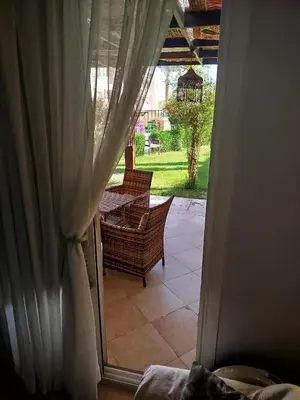 an open door to a patio with a table and chairs at Apartment with garden in sahl hasheesh in Hurghada