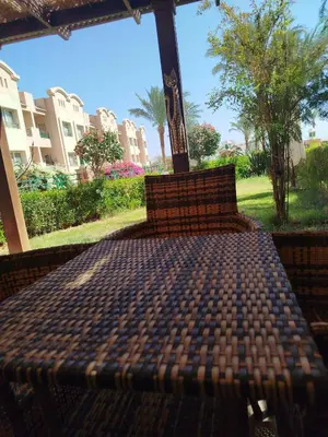 a bed in a porch with a view of a park at Apartment with garden in sahl hasheesh in Hurghada