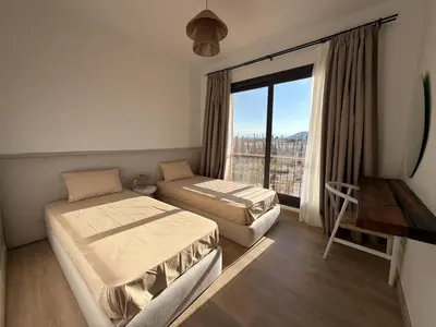 a bedroom with two beds and a large window at Fresh & Modern 2BR • Newly Furnished Kamaran in Hurghada