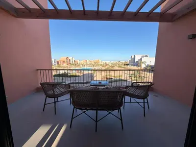 a patio with a table and chairs on a balcony at Fresh & Modern 2BR • Newly Furnished Kamaran in Hurghada