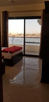 a bedroom with a bed and a large glass window at El BOB HOUSE in Luxor
