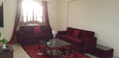 a living room with two red couches and a coffee table at El BOB HOUSE in Luxor