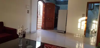 a living room with a door and a vase of flowers at El BOB HOUSE in Luxor