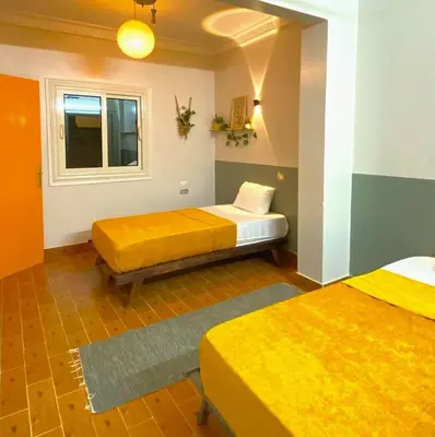 a room with two beds and a window at Jme Bunks Hostel in Aswān