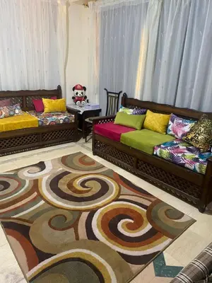 a living room with two couches and a rug at فيلا المدينة البعيدة in Naj‘ al Maḩaţţah