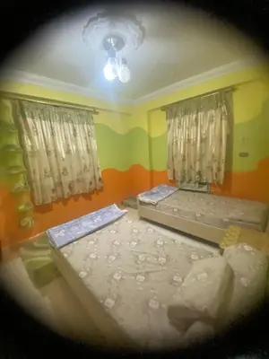 two beds in a room with two windows at فيلا المدينة البعيدة in Naj‘ al Maḩaţţah