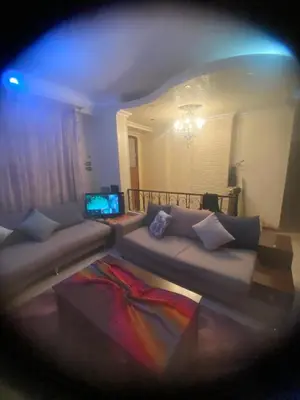a living room with a couch and a laptop at فيلا المدينة البعيدة in Naj‘ al Maḩaţţah