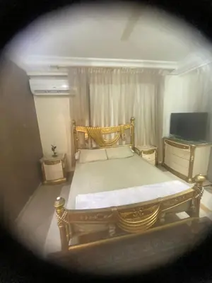 a bedroom with a large bed and a television at فيلا المدينة البعيدة in Naj‘ al Maḩaţţah