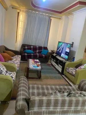 a living room with couches and a flat screen tv at فيلا المدينة البعيدة in Naj‘ al Maḩaţţah