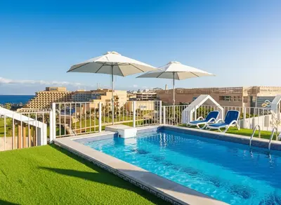 a swimming pool with two chairs and umbrellas at Hurghada luxury apartment sea view 5 in Hurghada