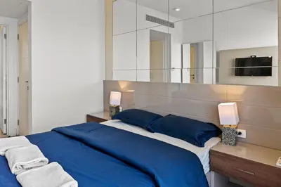 a bedroom with a blue bed and a large mirror at The Charming Beach Front Villa At Fanadir Bay W Private Pool in Hurghada