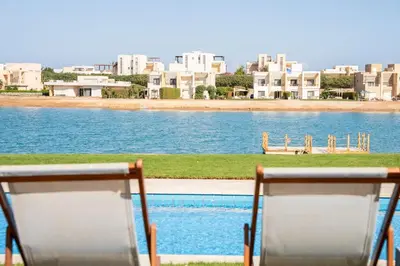 two chairs sitting in front of a body of water at The Charming Beach Front Villa At Fanadir Bay W Private Pool in Hurghada