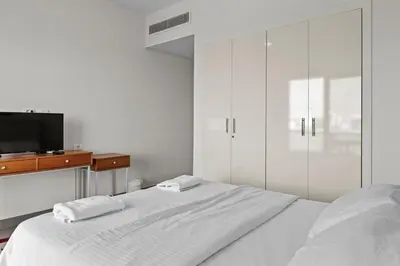 a white bedroom with a bed and a tv at The Charming Beach Front Villa At Fanadir Bay W Private Pool in Hurghada