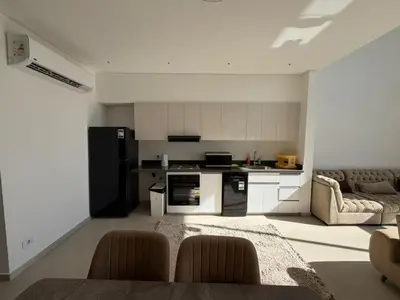 a kitchen and living room with a black refrigerator at Bright Kamaran 2BR | Lofty Ceilings & Pool Access in Hurghada