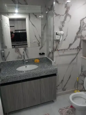 a bathroom with a sink and a mirror and a toilet at شقة اللؤلؤة in Hurghada
