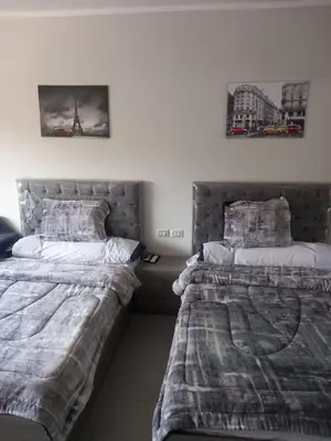 two beds sitting next to each other in a bedroom at شقة اللؤلؤة in Hurghada