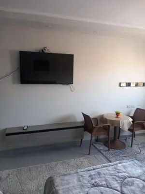 a living room with a tv on a white wall at شقة اللؤلؤة in Hurghada