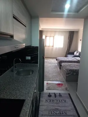 a kitchen with a sink and a room with a bed at Naseem Home in Hurghada