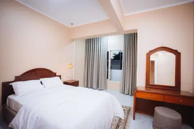 a bedroom with a white bed and a mirror at Karnak Temple Inn in Luxor