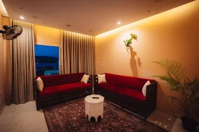 a living room with two red couches and a plant at Karnak Temple Inn in Luxor