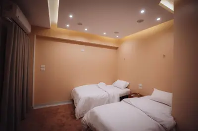 two beds in a hotel room with white sheets at Karnak Temple Inn in Luxor