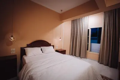 a bedroom with a large white bed and a window at Karnak Temple Inn in Luxor
