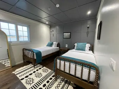a room with two beds in a room at Miss Fatima Dahabiya-Nile Cruise 4 night sailing-Includes English speaking Guide and site seeing -All inclusive excluding alcoholic beverages in Luxor