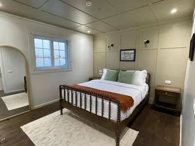 a bedroom with a bed and a window and a mirror at Miss Fatima Dahabiya-Nile Cruise 4 night sailing-Includes English speaking Guide and site seeing -All inclusive excluding alcoholic beverages in Luxor