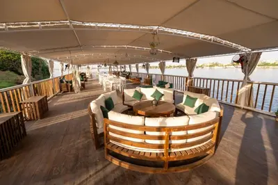 a restaurant on a boat with a table and chairs at Miss Fatima Dahabiya-Nile Cruise 4 night sailing-Includes English speaking Guide and site seeing -All inclusive excluding alcoholic beverages in Luxor