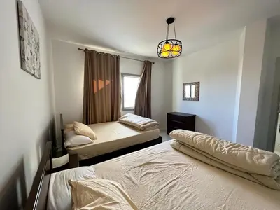 a bedroom with two beds and a window at 4BR Penthouse, Lagoon View, Swanlake El Gouna in Hurghada