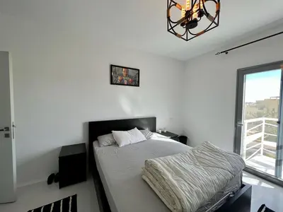 a white bedroom with a bed and a window at 4BR Penthouse, Lagoon View, Swanlake El Gouna in Hurghada