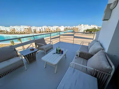 a balcony with couches and a table with a view at 4BR Penthouse, Lagoon View, Swanlake El Gouna in Hurghada
