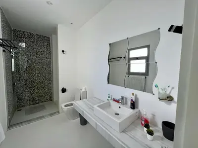 a white bathroom with a sink and a shower at 4BR Penthouse, Lagoon View, Swanlake El Gouna in Hurghada
