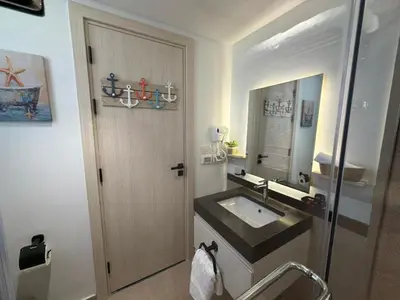 a bathroom with a sink and a wooden door at Spacious Gouna Studio | Pool Access + Terrace in Hurghada