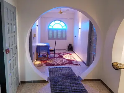 a hallway with a round mirror in a room with a table at Rafe Guest House in Luxor