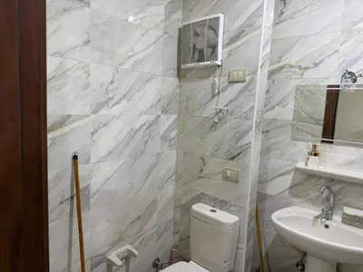 a white bathroom with a toilet and a sink at Tiba Golden Beach Hurghada in Hurghada