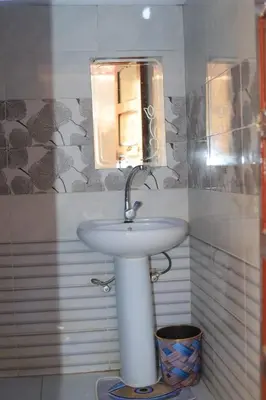 a bathroom with a white sink and a mirror at Moonlight in Al Aqālitah