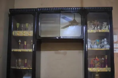 a black cabinet with glass doors and shelves at Moonlight in Al Aqālitah