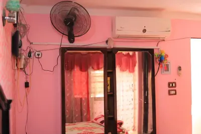 a room with a pink wall and a fan at Moonlight in Al Aqālitah