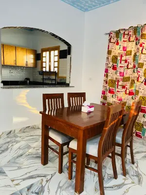 a dining room with a wooden table and two chairs at Horus Golden Luxor in Luxor