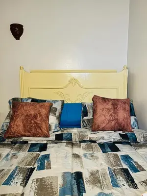 a bedroom with a bed with a blue and white comforter at Horus Golden Luxor in Luxor