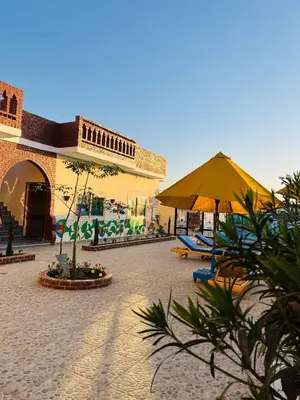 a courtyard with umbrellas and chairs and a building at Horus Golden Luxor in Luxor