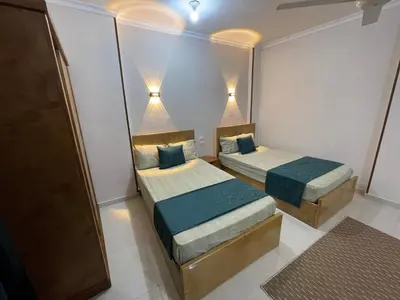 a small room with two beds and two lights at Luxe Nest Luxor Serviced Apartments 302 in Luxor