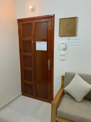 a wooden door in a room with a couch at Luxe Nest Luxor Serviced Apartments 302 in Luxor
